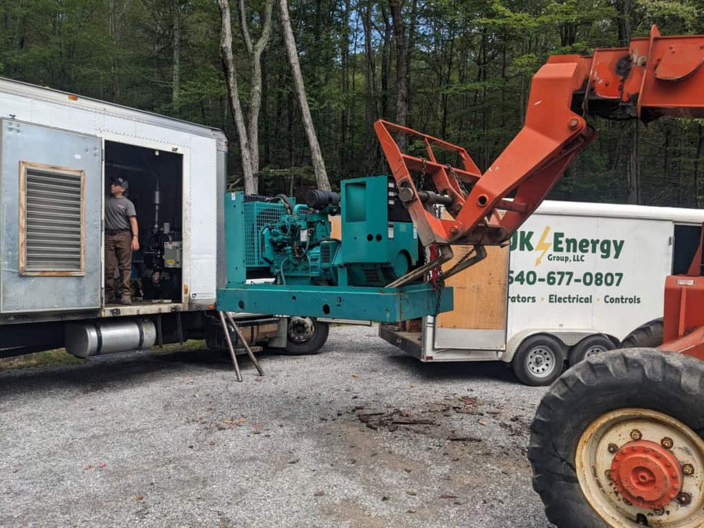 Installing a generator into a mobile truck unit after maintenance.