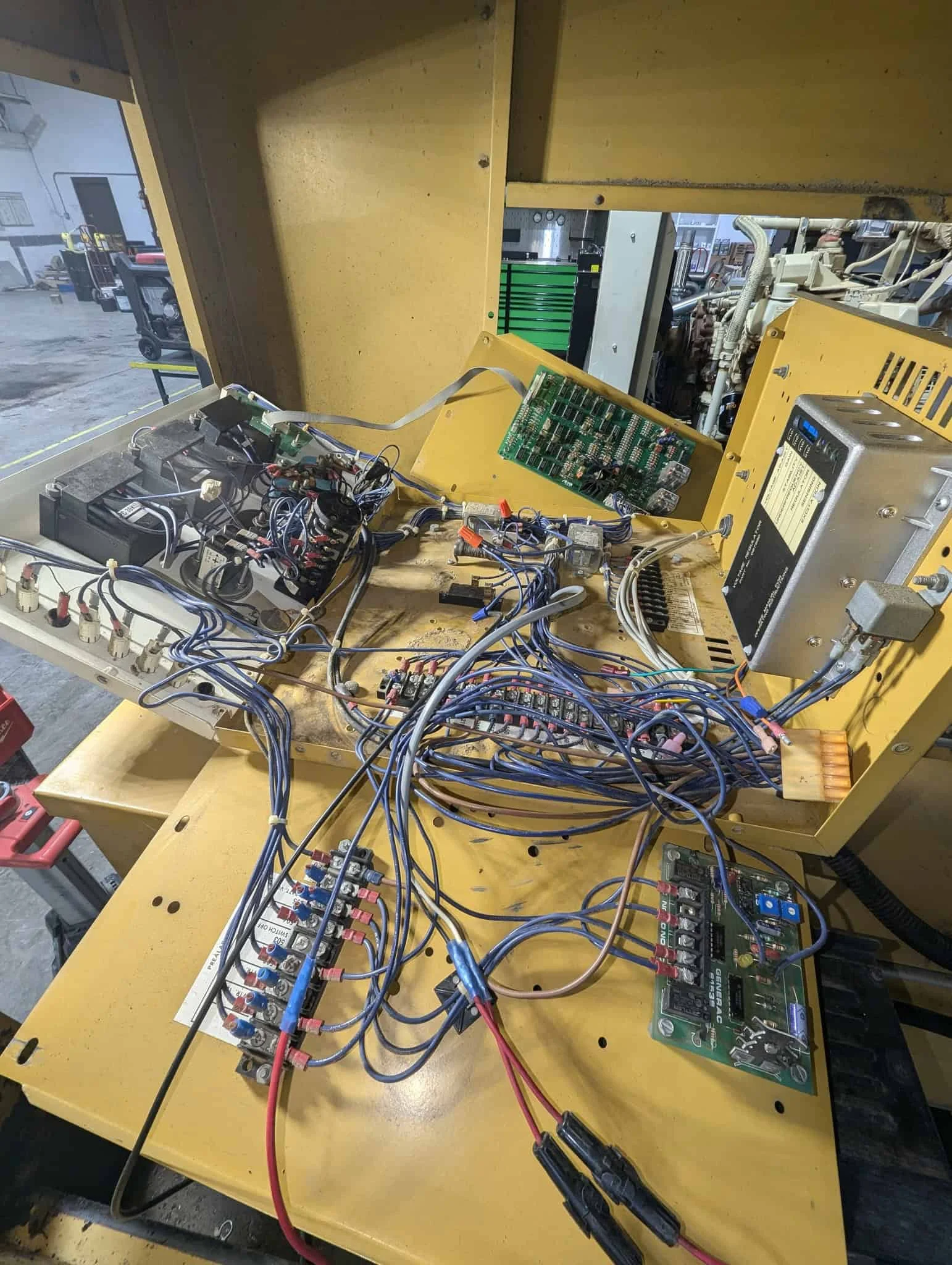 Close-up of an open generator control panel showing circuit boards, wiring, and electrical components for maintenance and repair.